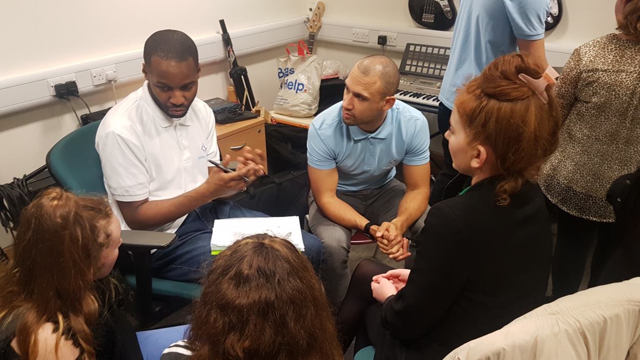 Young people working on lyric writing with tutors