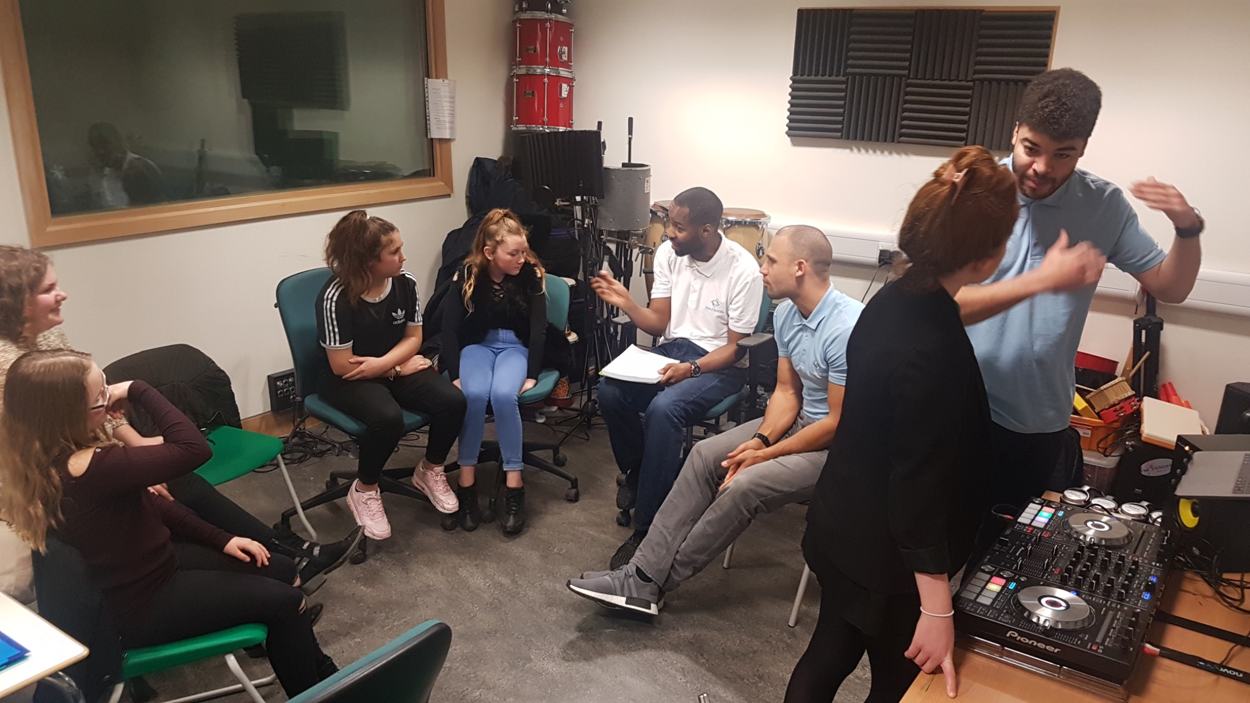 Tutor supporting young people during a workshop